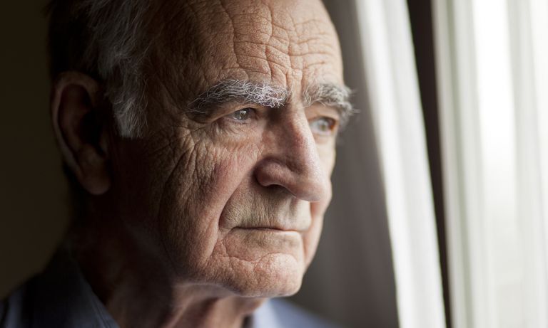 mature man gazing out window