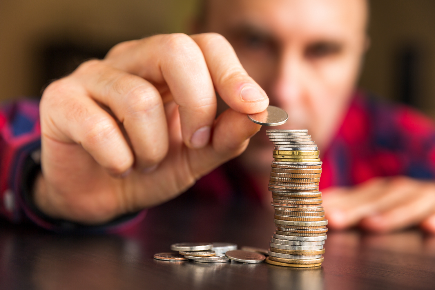 Man counting a stack of coins